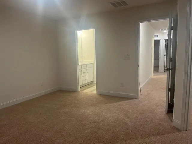 an empty room with closet and a bathroom