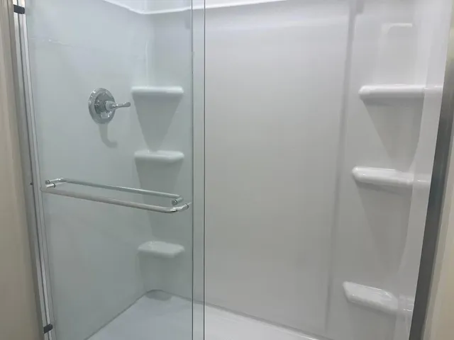 a white toilet sitting next to a shower