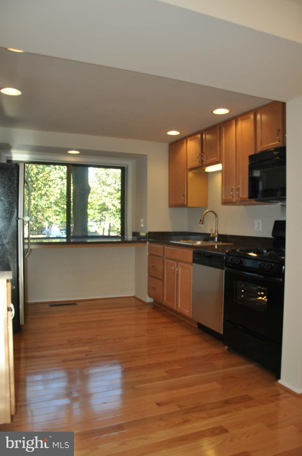 9415 Merryrest Road Columbia, MD 21045 - Photo 6 of 17 a kitchen with granite countertop a stove and a sink