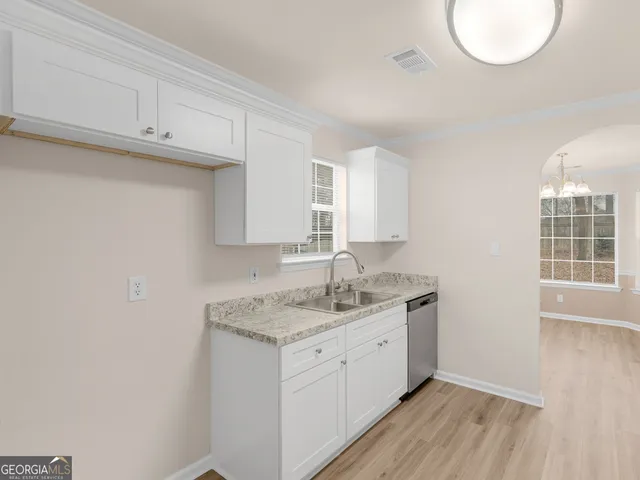 a room with a sink cabinets and wooden floor