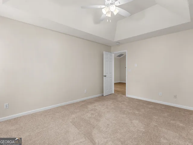 a view of an empty room with a chandelier fan