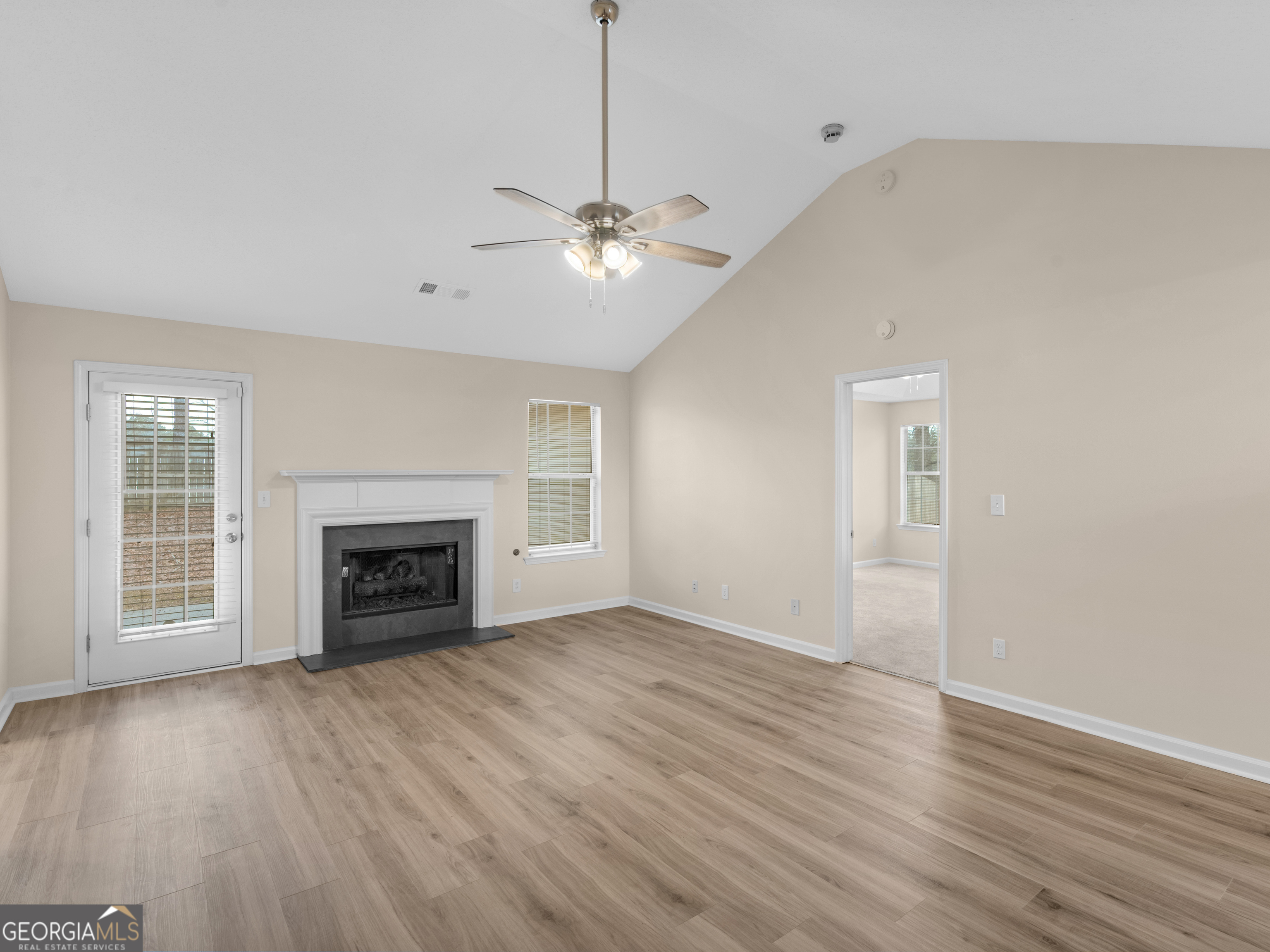 729 Old Stone Court Stockbridge, GA 30281 - Photo 6 of 47 a view of an empty room with wooden floor fireplace and a window
