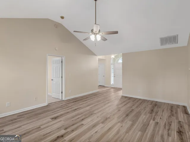 a view of an empty room with wooden floor