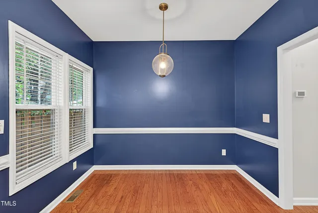 a view of wooden floor in an empty room with a window