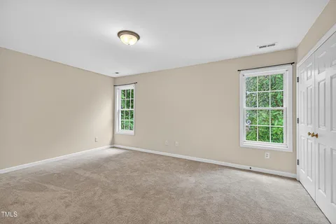 an empty room with windows and closet