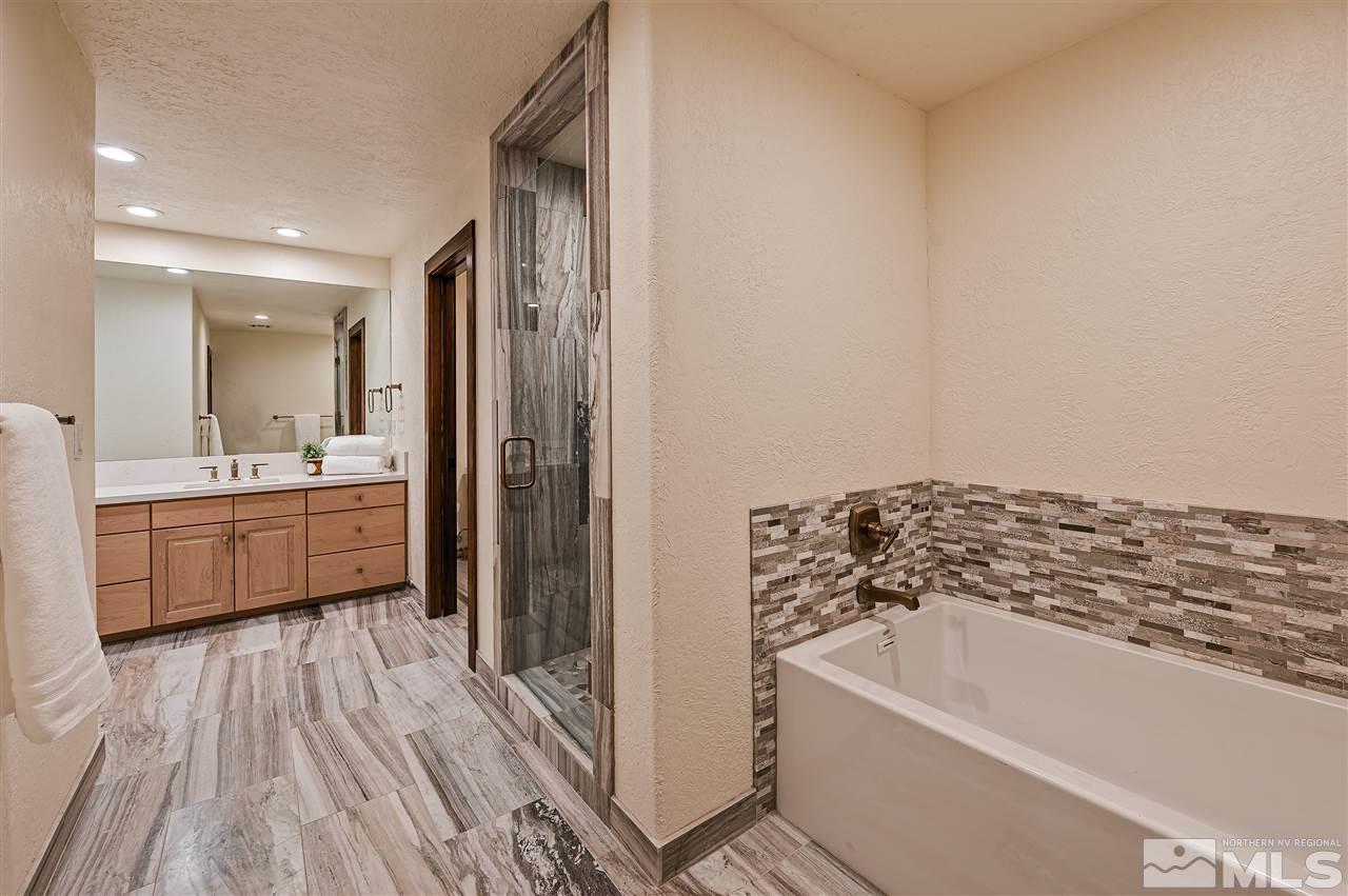 110 Sawbuck Road Reno, NV 89519 - Photo 24 of 40 a bathroom with a bathtub a sink a mirror and a shower