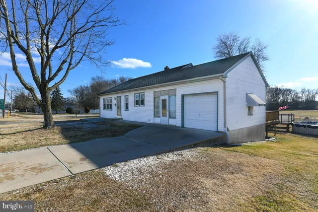 a view of a house with backyard and a tree