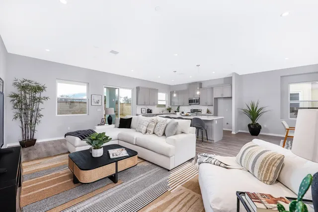a living room with furniture kitchen and windows