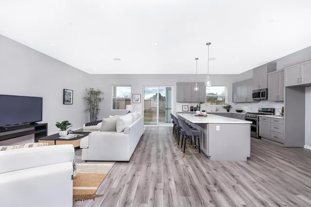 a large white kitchen with a large window and stainless steel appliances