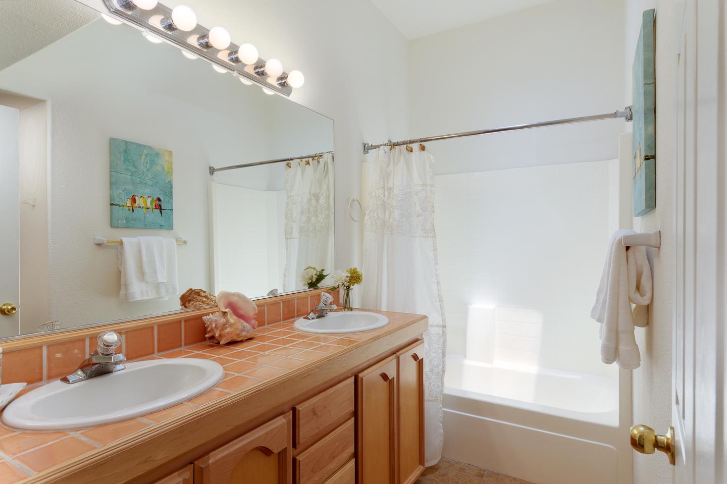 892-894 Calabasas Road Watsonville, CA 95076 - Photo 29 of 53 a bathroom with a granite countertop sink a mirror and a shower