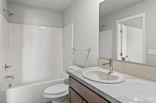 a bathroom with a granite countertop sink toilet a mirror and shower