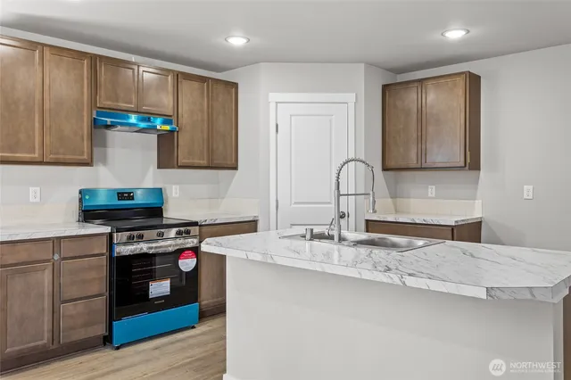 a kitchen with stainless steel appliances granite countertop a sink stove and cabinets