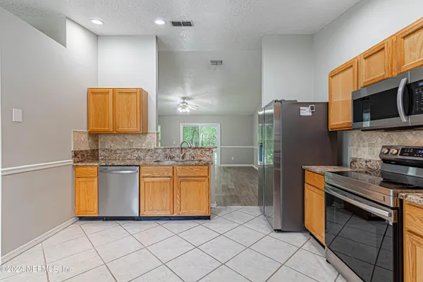 a kitchen with stainless steel appliances granite countertop a stove a sink and a refrigerator