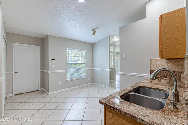 a kitchen with granite countertop a sink a stove and cabinets