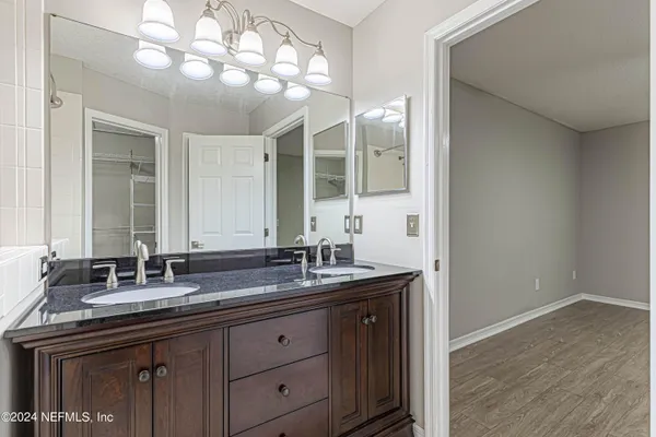 a bathroom with double sink and a mirror