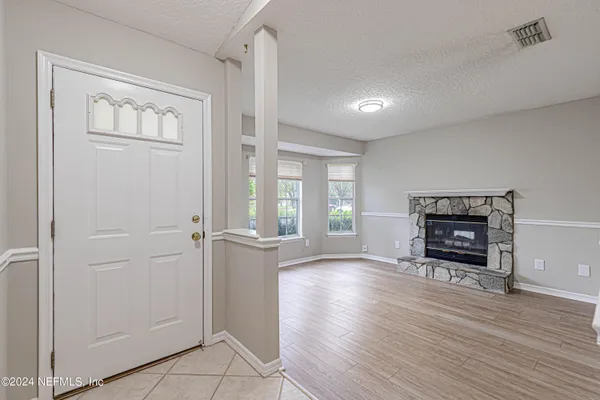 an empty room with windows and fireplace