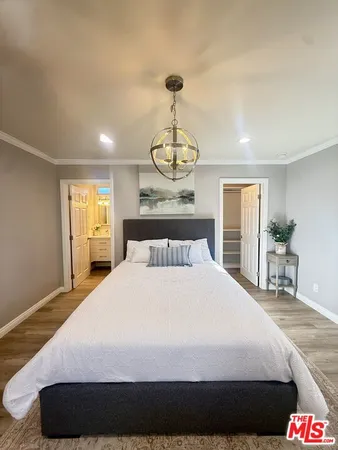 a bedroom with a bed and a chandelier