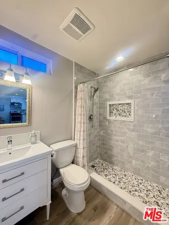 a bathroom with a toilet sink shower and mirror
