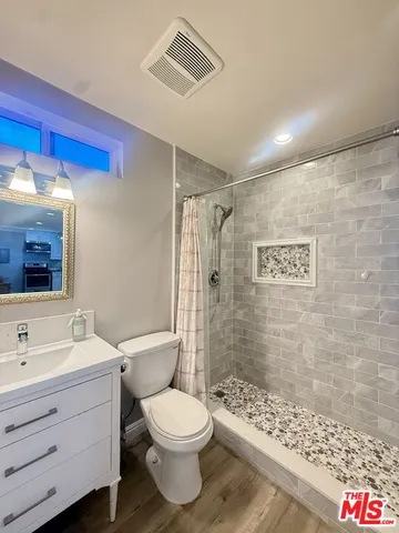 a bathroom with a toilet sink shower and mirror