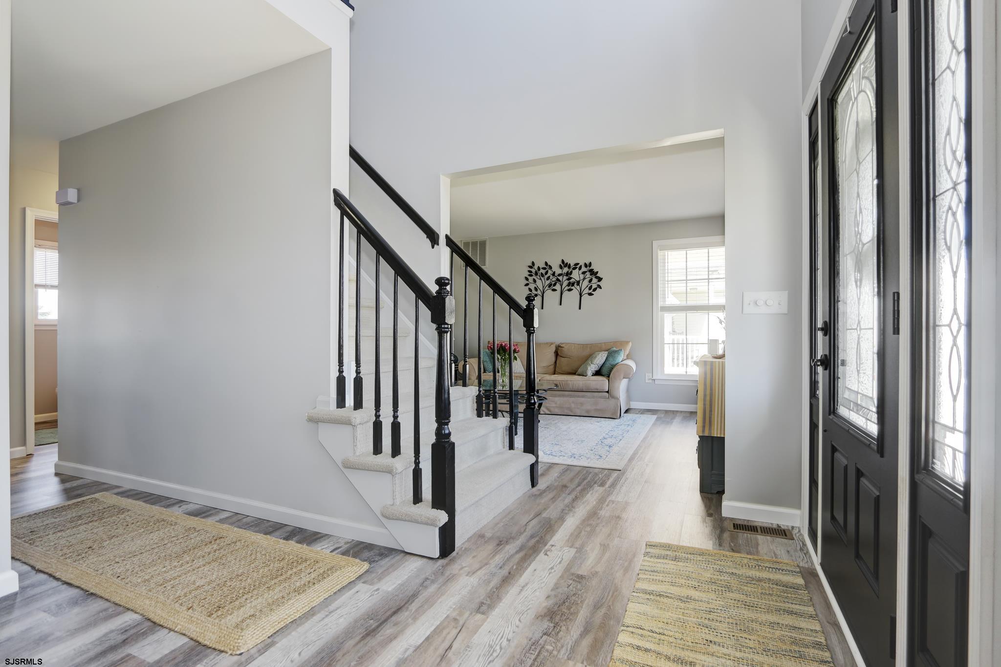 218 Hagen Road Brigantine, NJ 08203 - Photo 8 of 32 a view of a hallway to a livingroom with wooden floor and staircase