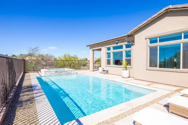 a view of a house with pool and sitting area