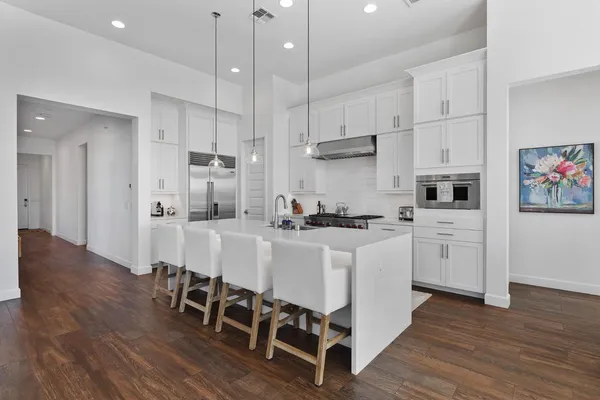 a large white kitchen with stainless steel appliances