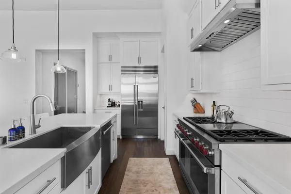a kitchen with stainless steel appliances a sink stove and refrigerator