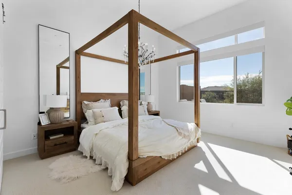 a bed sitting in a bedroom next to a window