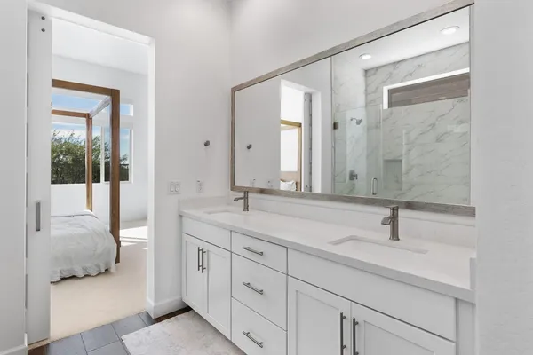 a en suite bathroom with double sink and a mirror
