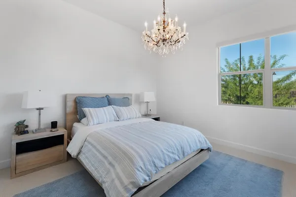 a bedroom with a bed and a chandelier