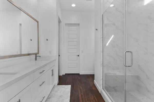 a bathroom with a shower sink and mirror