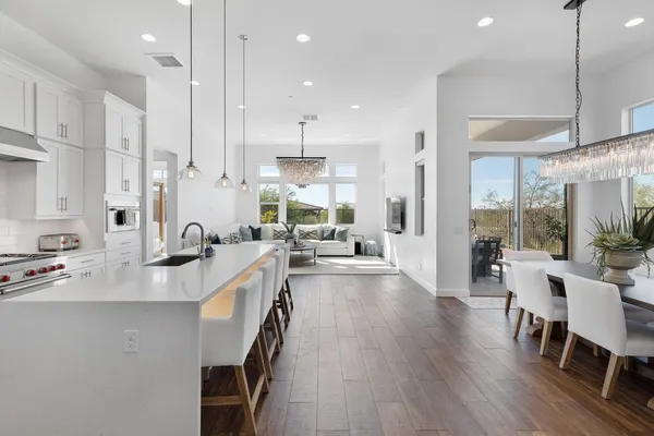 a large kitchen with kitchen island lots of counter space a sink appliances and a dining table