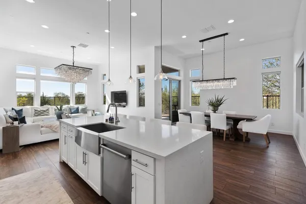 a large kitchen with stainless steel appliances kitchen island a white counter space and a living room view