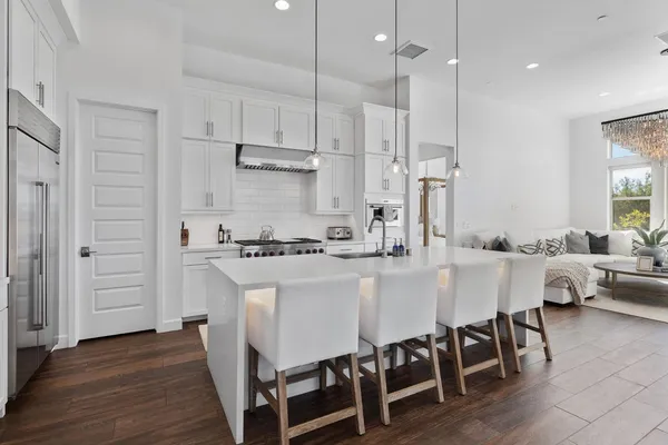 a white kitchen with wooden floors and white cabinets