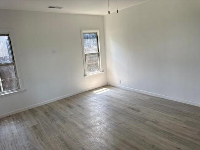 Wood-finish flooring with white walls and trim, complemented by two windows with white frames