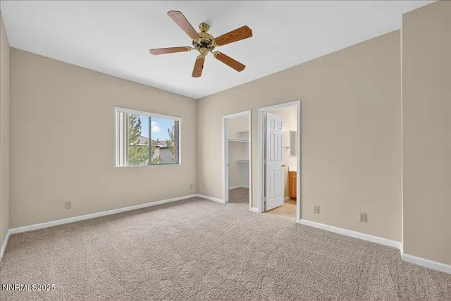 an empty room with a ceiling fan and windows