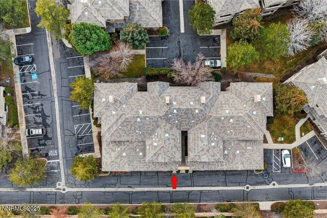 an aerial view of a house with a yard and large tree
