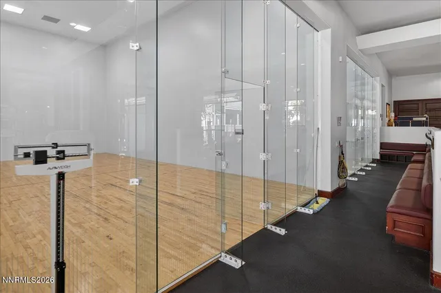 a living room with furniture large windows and wooden floor