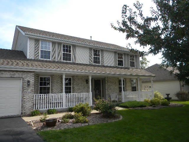 10745 Chicory Ridge Way Roscoe, IL 61073 - Photo 1 of 25 a front view of a house with a garden