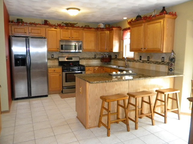 10745 Chicory Ridge Way Roscoe, IL 61073 - Photo 8 of 25 a kitchen with stainless steel appliances granite countertop a refrigerator and a stove top oven