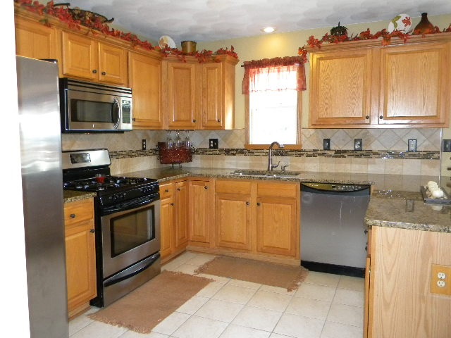 10745 Chicory Ridge Way Roscoe, IL 61073 - Photo 9 of 25 a kitchen with stainless steel appliances granite countertop a stove a sink and a microwave