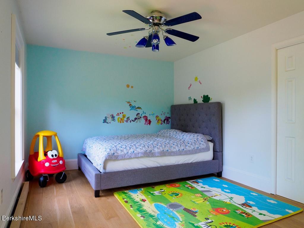 664 Main Road Monterey, MA 01245 - Photo 14 of 19 a bedroom with a bed and a chandelier