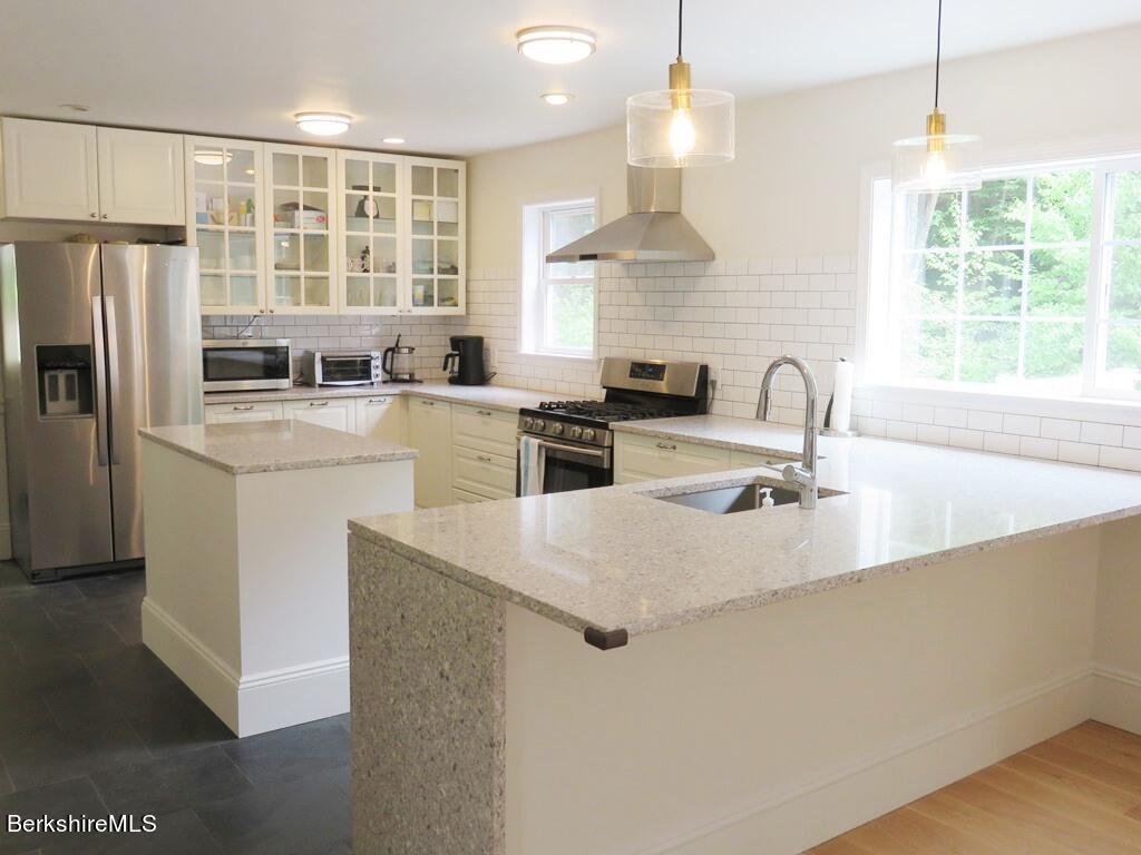 664 Main Road Monterey, MA 01245 - Photo 5 of 19 a kitchen with stainless steel appliances a sink a stove a refrigerator a center island a stove and a window