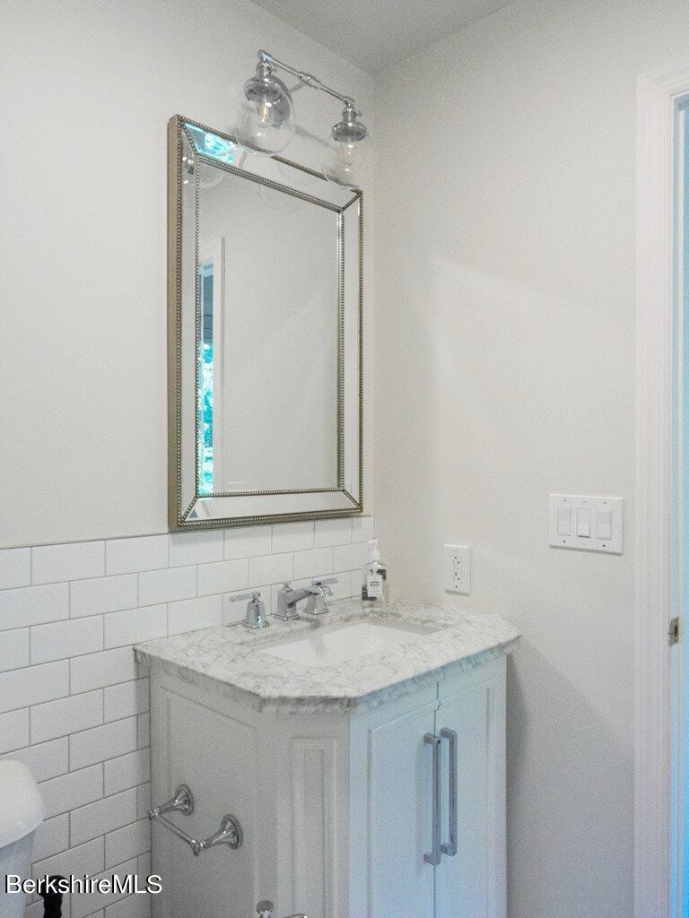 664 Main Road Monterey, MA 01245 - Photo 9 of 19 a bathroom with a granite countertop sink a mirror and a vanity