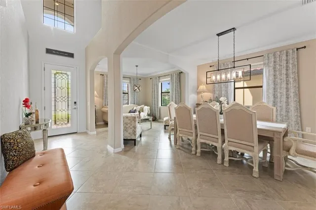 a living room with furniture a dining table and a chandelier