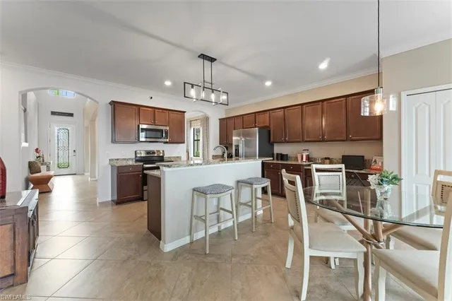 a view of kitchen with microwave stove refrigerator and cabinets