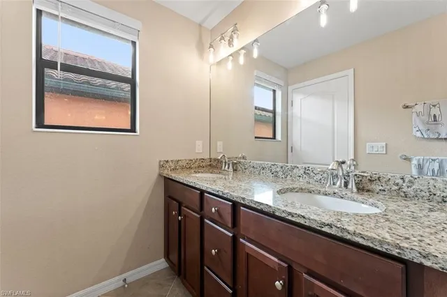 a bathroom with a granite countertop sink a vanity and a mirror