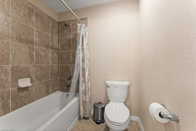 a white toilet and tub sitting next to a bathroom sink