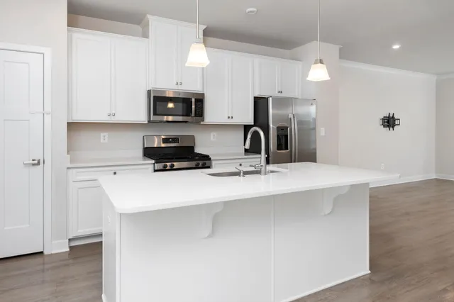 a kitchen with stainless steel appliances a sink a stove a microwave and cabinets