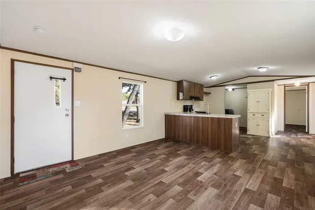 a view of a big room with wooden floor and windows